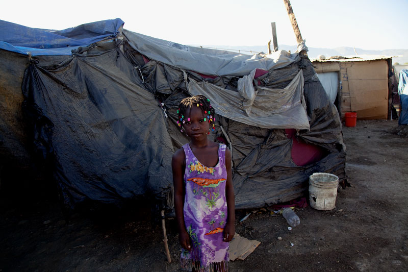 At Pont-Rouge refugee camp, 7 year old Haitian earthquake survivor Sabaline Estiven stands in front of her friend's tent. 