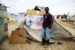 At Pont-Rouge refugee camp, Jeune Wadsonn, 24 year old Haitian earthquake IDP, stands in front of his tent where he and his 2 sons and 6 sisters live together.