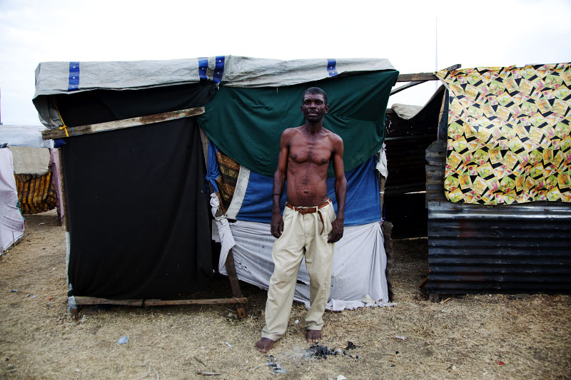 At Pont-Rouge refugee camp, Claudel Louimas, 52 year old Haitian earthquake IDP, stands in front of his tent where he and his 3 children and wife live together. He lost two cousins due to the January 12th quake.