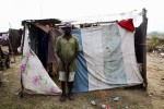 At Pont-Rouge refugee camp, holding a saw, Luckner Naveau, 40 year old Haitian earthquake IDP, stays in front of his shelter where he lives with other 4 family members.