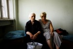 Newly arrived internally displaced people -- Maro Babucidze, 70, from Tskhinvali in South Ossetia, on the left, and Iveli Masmishvili, 44, from Tirdznisi village of Gori district -- stay at a former Soviet military compound in Tbilisi, the capital of Georgia, as Russian troops continue to occupy large parts of the country. Aug 17, 2008.