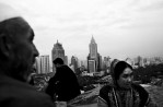 A Uighur couple and two Han Chinese men at an Urumqi park overlooking the province capital's new buildings. 