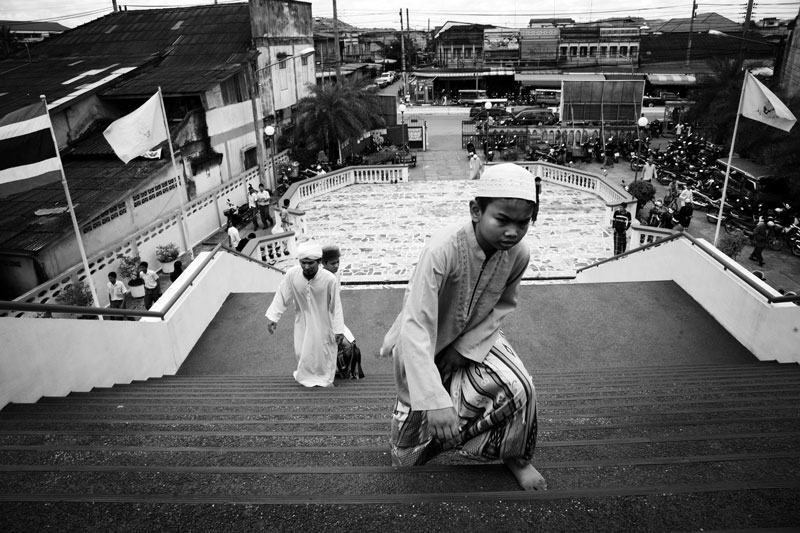 A child climbs up stairs to take the noon prayer at Yala Central Mosque in South Thailand, where the majority is Muslims and the Muslim separate insurgency continues. April 04, 2008, Yala, Thailand.