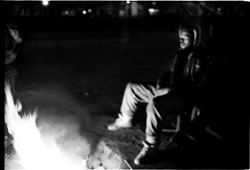 A homeless man in Tompkins Sq Park warms himself in front of a bonfire, as the rumor of the incoming forceful eviction by NYPD spread during harsh winter. December 1989.
