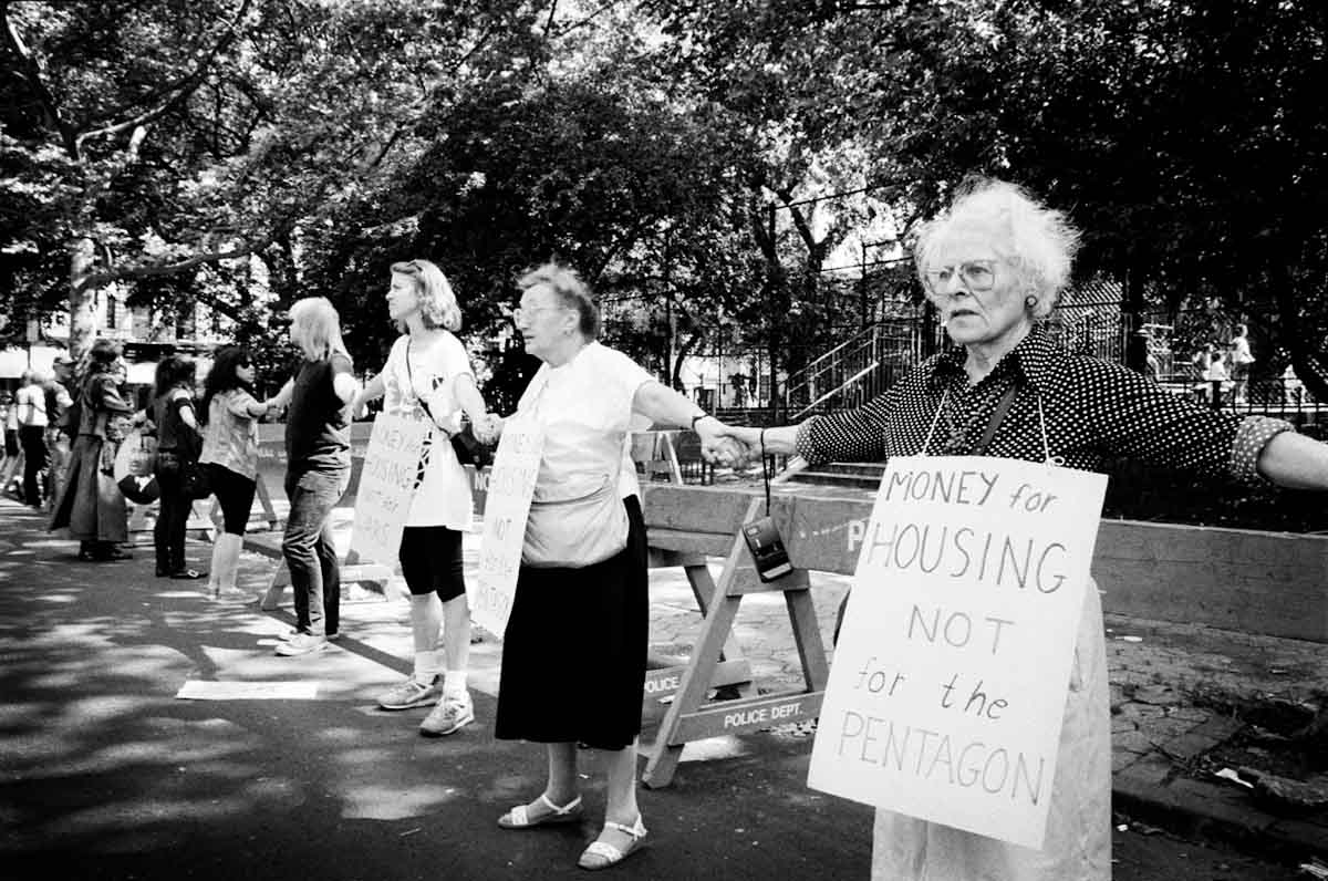 Surrounding Tompkins Sq Park, Lower Eastside residents show solidarity in hands in hands to protect the park's planned closure by the New York city government. Many rights advocates have denounced the plan as a too drastic gentrification tool. June 1991.