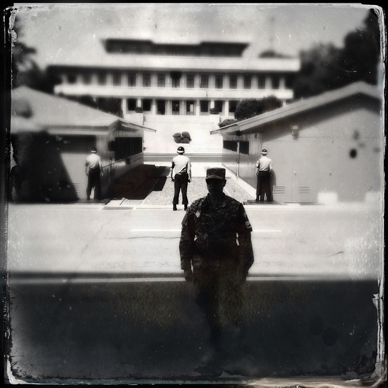 An American solider (front) and three Korean soliders stand at JSA( Joint Security Area), Panmunjeom, South Korea. The white building belongs to North Korean Side. 