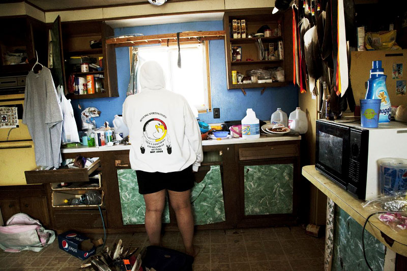 28 year old Native American Lakota woman Andrea stays at the kitchen of her trailer house in the Pine Ridge reservation. She and her husband are unemployed for more than a year. Although they want to leave the reservation to find a job, but they don’t have such money as for the rent of the apartment in the new place and even the transportation. 