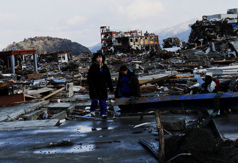 Two crying girls, survivors of the unprecedented tsunami, wander in the destroyed village of Minami-Sanriku. More than half of Minami-Sanriku's population have disappeared due to the tsunami.