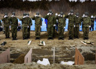Japanese soldiers salute victims of the monster tsunami at a mass burial site in Oshio district in Higashi-Matsushima, Miyagi.