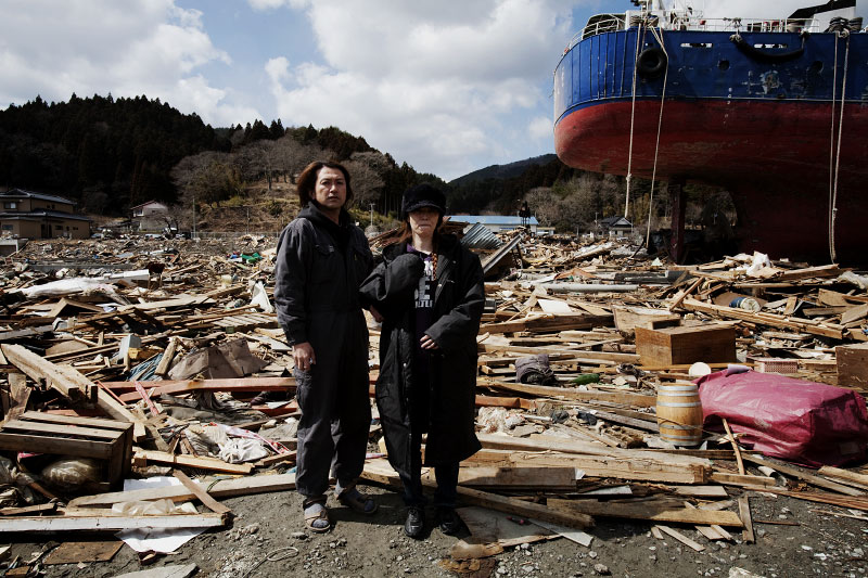 The cople -- Mitsuru Konno, 41, and his wife Sakiko, 47, stand in front of their tsunami destroyed house in Kesennuma.