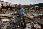 Tsunami survivor Takezo Iegashi 70, poses at the debris of his destroyed house, as he is searching for any memorial items and anything worth.