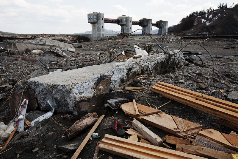 Tsunami destroyed part of a road remains near an anti-high tide gate that critics regard as white elephant. Otsuchi, Iwate.