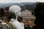 A survived statue of a Buddha remains at a cemetery, as the tsunami destroyed areas of Otsuchi are seen downward.