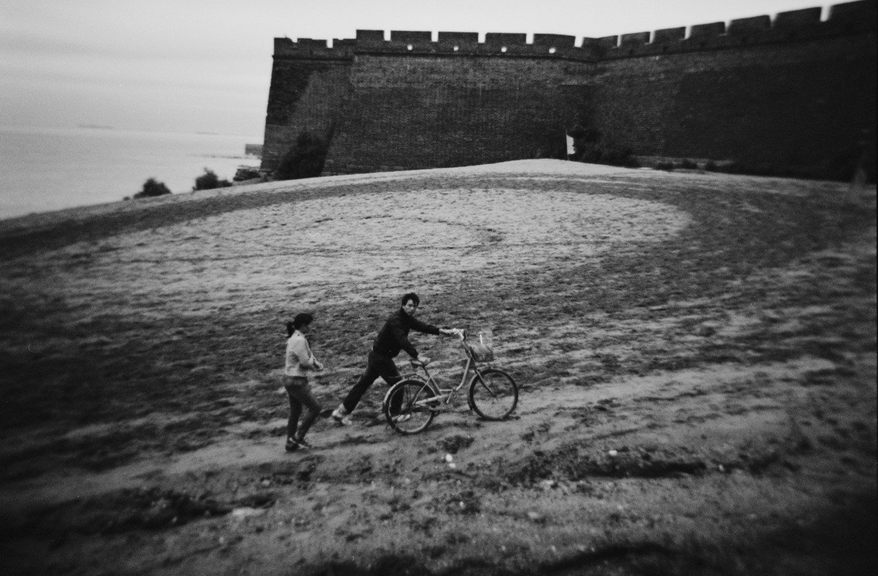 A couple, with a bicycle, walks near Lao Long Tou, or Old Dragon's Head, in Shanhaiguan that had experienced many severe fightings in the history between the Han Chinese and people from the North, such as Khitns and Manchus. Lao Long Tou is the starting point of China's famous Great Wall and at the point the wall meets the sea. The lands to the North East of the Great Wall was once called Manchuria.China's North East was once called Manchuria. The region was at a crossroads that was manipulated in history, including the occupation by Russia and Japan. And now the area is facing upheavals due to the globalization with China’s rapid economic growth itself, creating the gap between the rich and the poor and even more unemployment and worrying for the future.