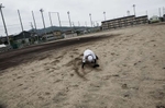 Kenta Yamaki, 17, whose grandmother died due to the tsunami and school was closed due to the Fukushima Daiichi nuclear disaster, falls down to the playground during the baseball training. Aug/ 2011, Fukushima-city.