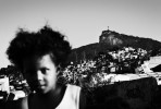 A girl stays at her favela Cidade Nova where poverty, unemployment and violence are rampant, and behind it, the statue of Jesus Christ of Corcovad is seen. May 2007. 