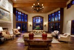 Interior family living room with fireplace, wooden flooring, and high glass windows