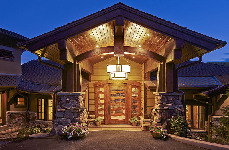 Exterior front entrance of home with overhanging wooden roof