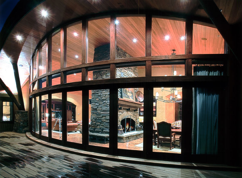 Exterior deck view of interior curved glass windows. 