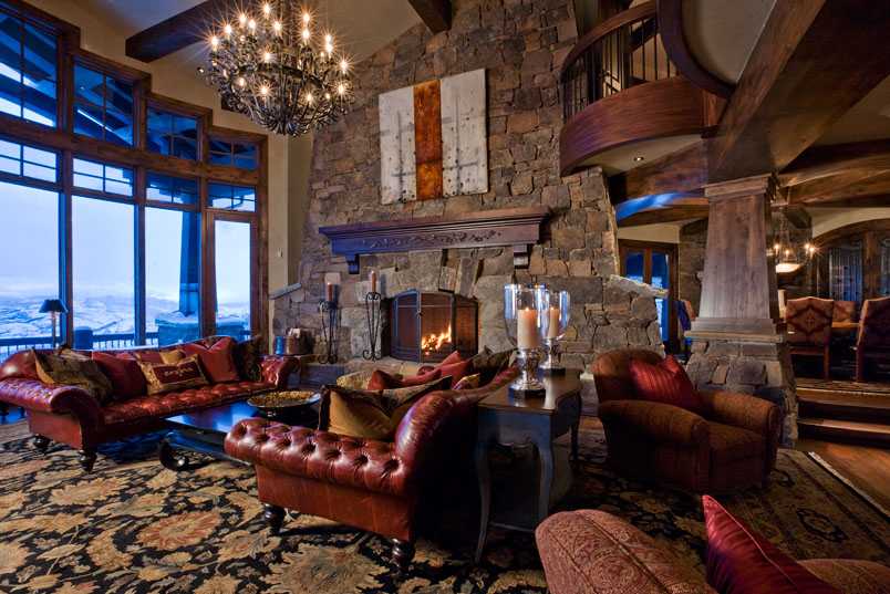 Interior family living room with fireplace, high ceilings and tall windows leading to outside deck. 
