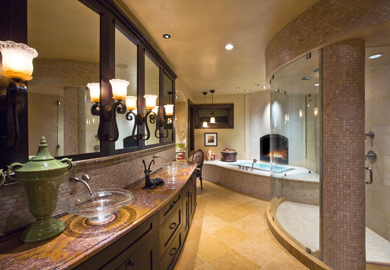 Interior lower level bathroom with matching sinks, bathtub and glass shower.
