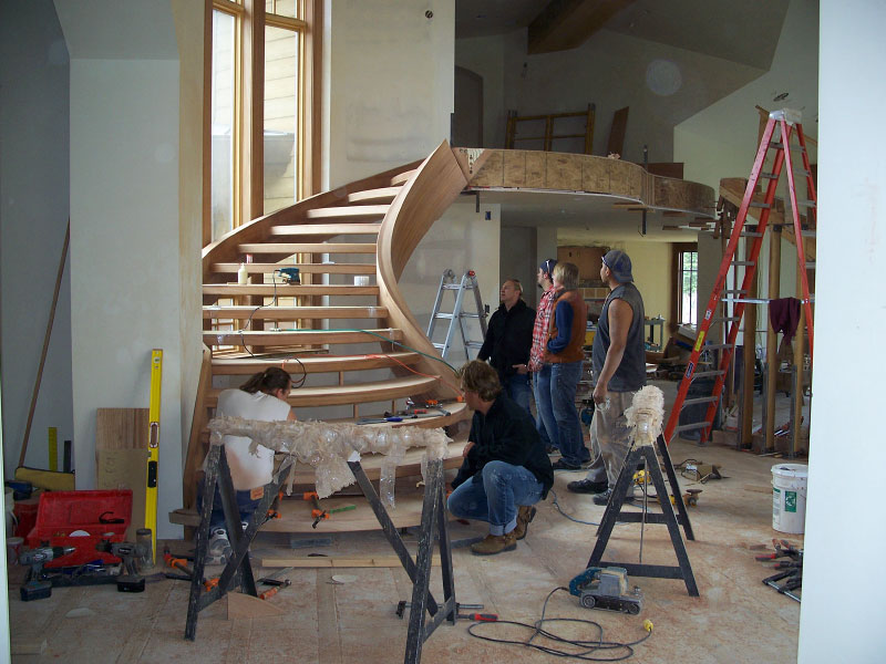 Interior wooden stairwell under construction being evaluated by upwall employees
