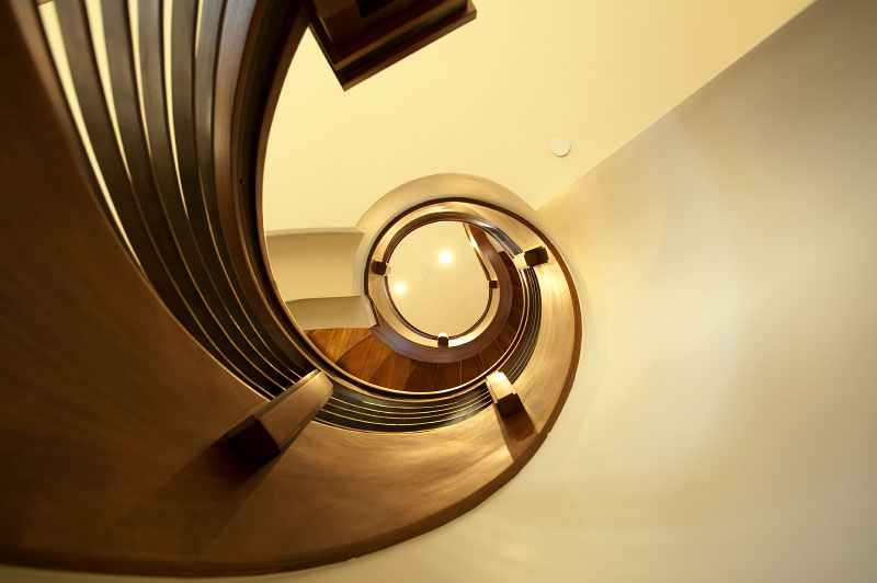 Interior lower level view of wooden spiral staircase 