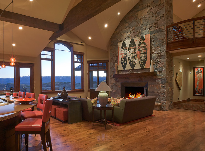 Interior upper level fireplace, wooden flooring, and family living area.  