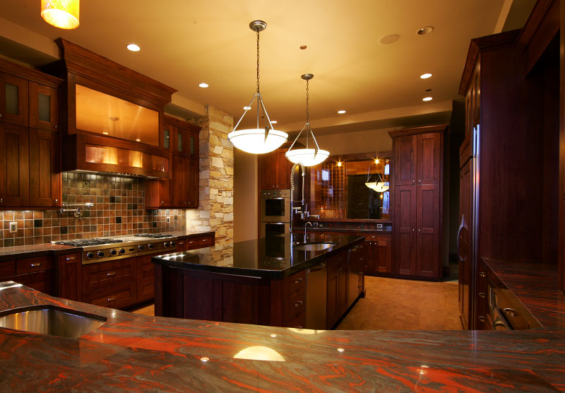Interior kitchen with marble granite countertops, and wooden cabintry. 