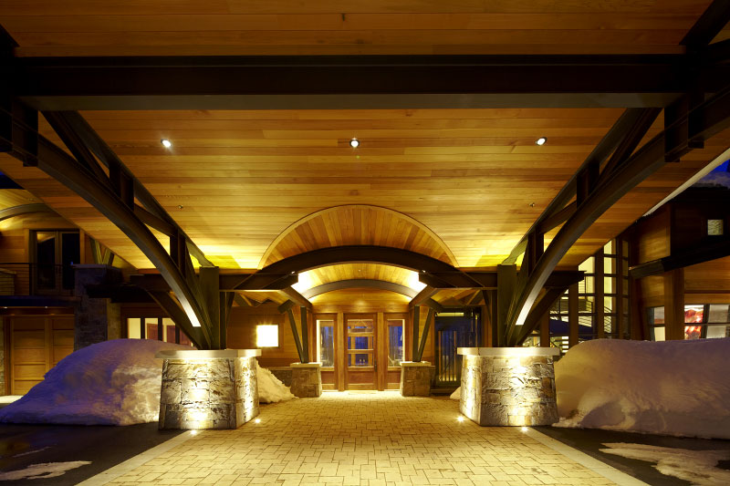 Exterior front entrance under porte cochere with wooden paneling on ceiling 