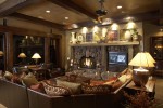 Interior lower level living room with fireplace, entertainment setup