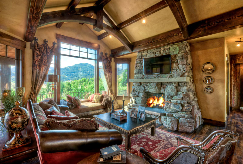 Interior family room with fireplace and upper level deck leading out to a scenic view 