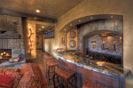 Interior lower level bar with marble countertops and fireplace 