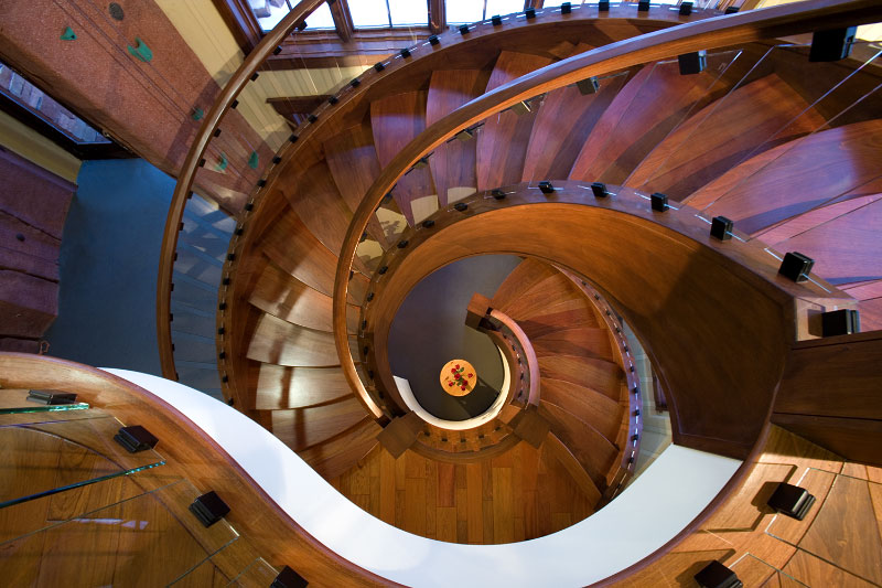 Interior upper level view of wooden spiral staircase 