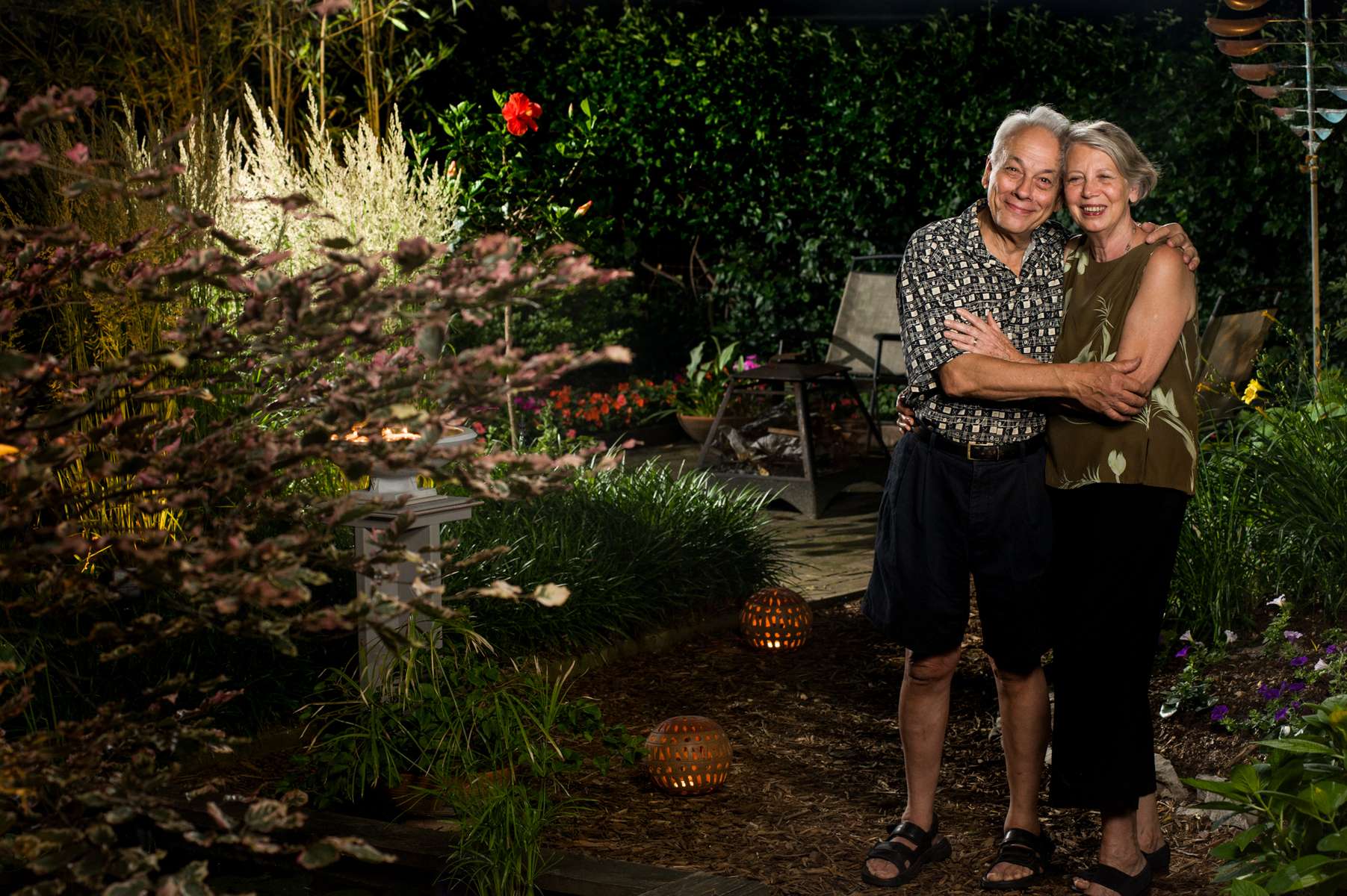 A loving couple share a hug and their love for one another in their beautiful garden on a pleasant summer evening.