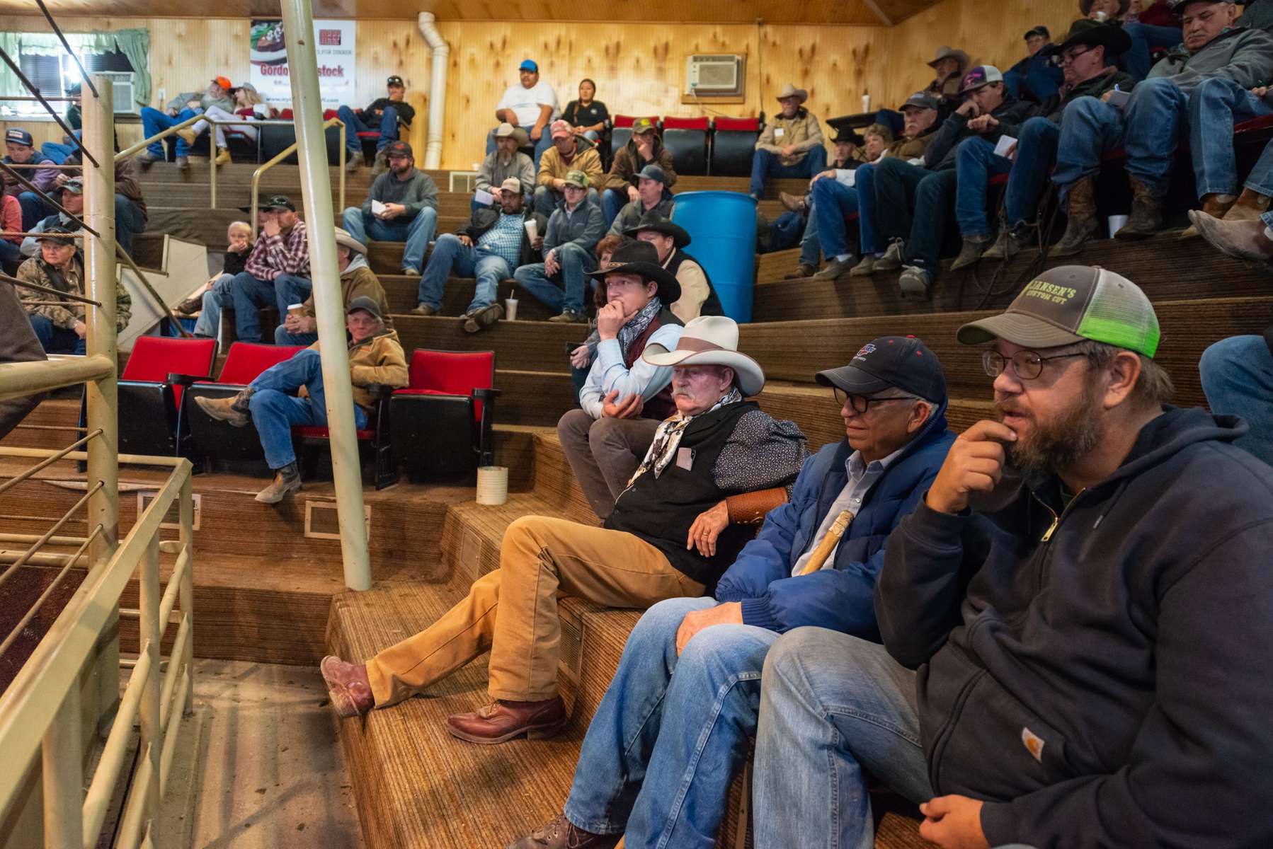 Justin Manning and Ray Stokes, center, along with other sellers and bidders take in the auction.