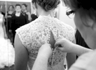 Close family friend Sharon buttons up the dress at the Jacksonville Country Club. Wedding photography by Steve & Tiffany Warmowski.