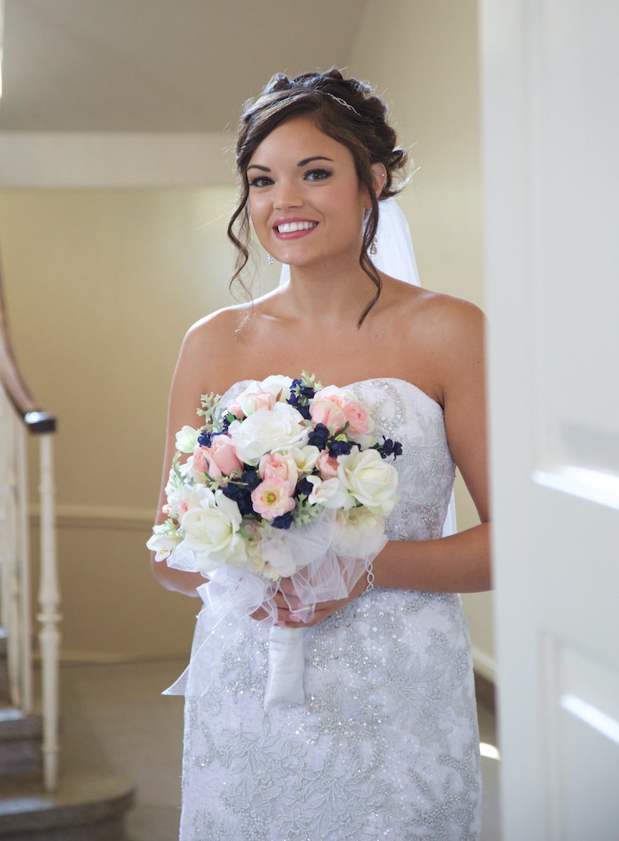 Adria peeks out from the background as she waits to walk down the aisle with her father, MacMurray College's Annie Merner Chapel, Jacksonville, Illinois. Wedding photography by Steve & Tiffany Warmowski.