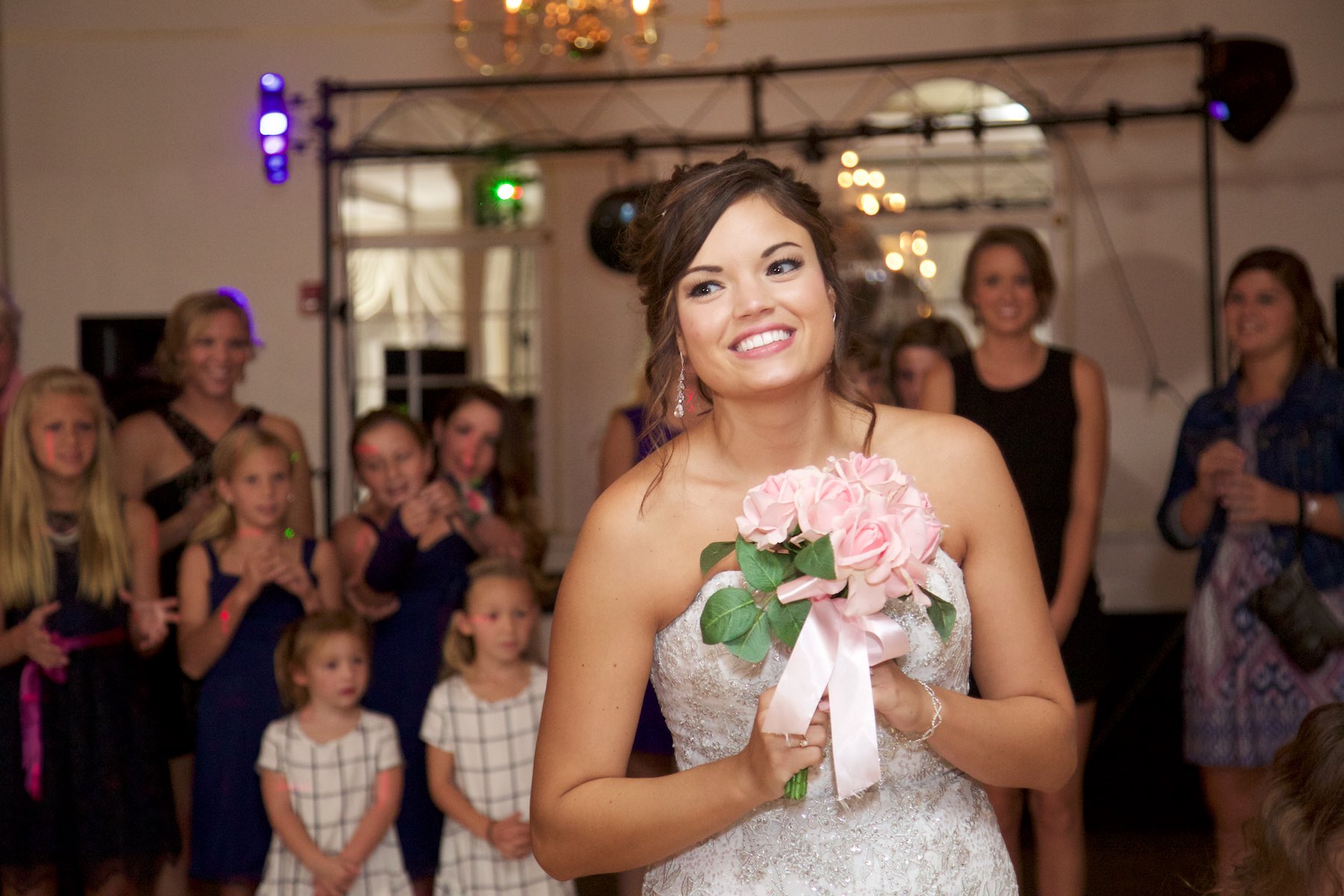 Bouquet toss, wedding reception at Hamilton's 110 North East, Jacksonville, Illinois. Wedding photography by Steve & Tiffany Warmowski.