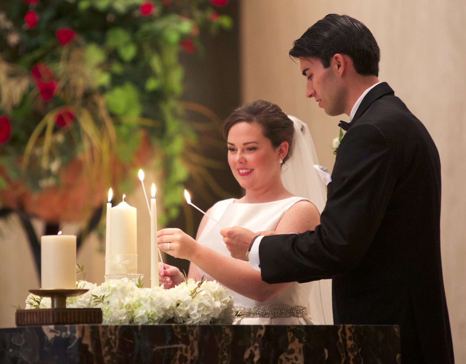 Lighting the unity candle, Elizabeth & Daniel's wedding ceremony at St. Rita of Cascia Shrine Chapel in Chicago. Wedding photography by Steve & Tiffany Warmowski