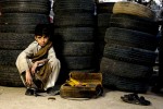 Shoe Shine boy, working outside the auto and tire shops behind Super Market area, Islamabad