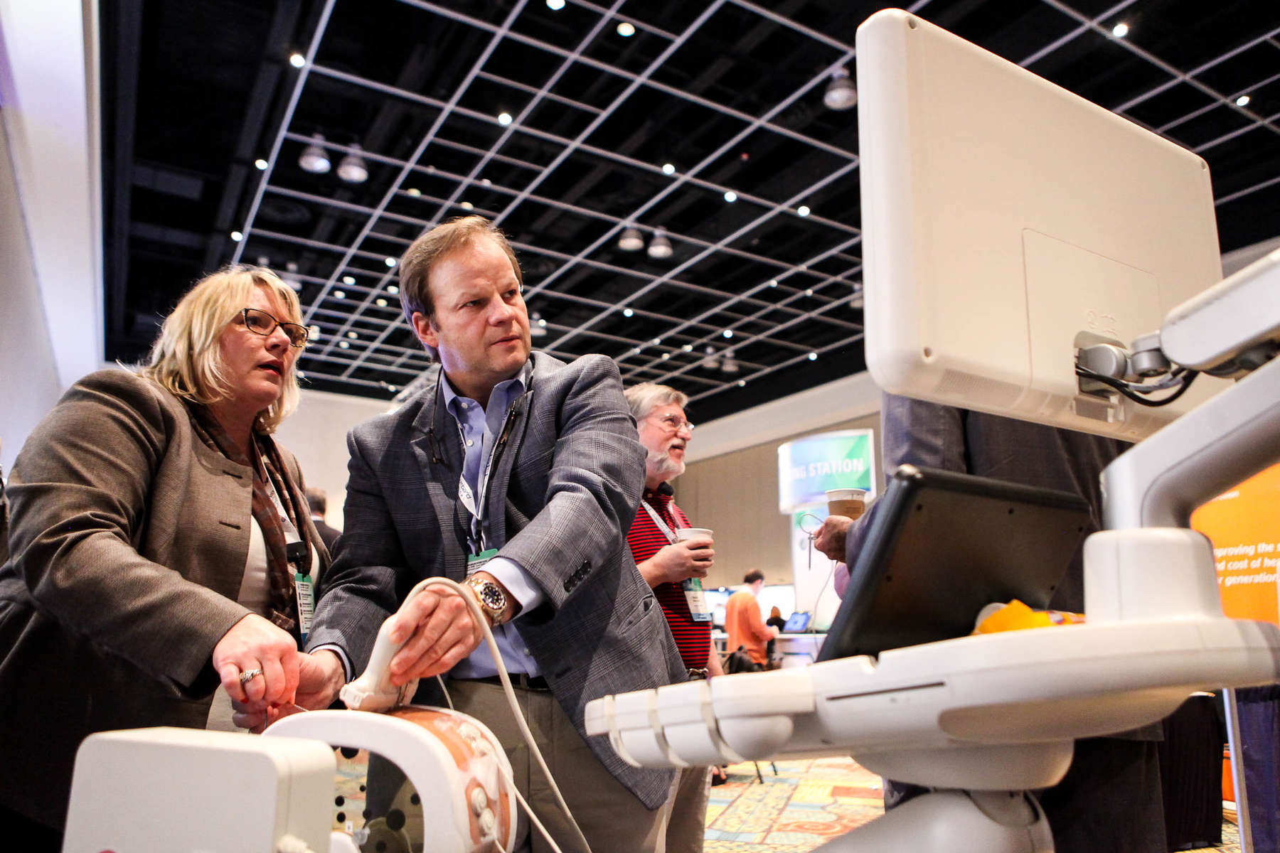 Monica Fuller shows Dr. Sven Kuestermann fusion and navigation technology with the Phillips PercuNav Epiq 7 Ultrasound system in the exhibit hall.