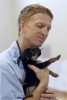 Todd Berlier a 4th year DMV student at Colorado State checks a puppy 