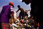 Workers climb over mountains of trash as they look for recyclable goods.