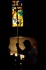 A man holds a cross as he goes through the stations of the cross in a church in Manila, Philippines.