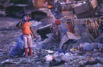 A young girl looks over a mountain of trash before starting her dailywork at the Payatas.