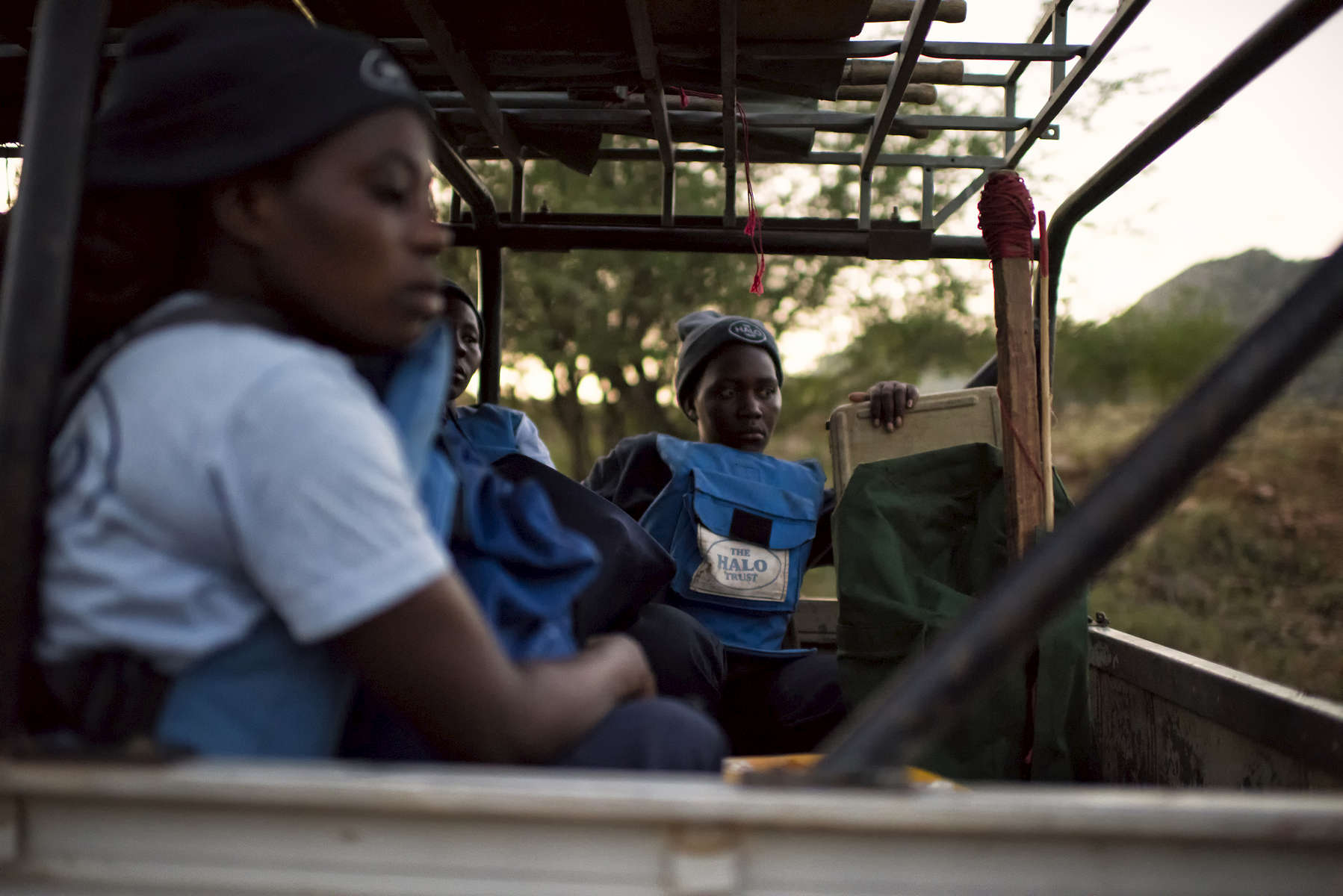 May 3, 2018: KANENGUERERE, ANGOLA - HALO deminer Valentina Sikato sits in the back of the truck as HALO staff drop off equipment at the minefields on their first day back at work in Kanenguerere.  