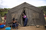 May 4, 2018: KANENGUERERE, ANGOLA -  HALO deminers Ana Bimbi Dumbo and Esperança Ngando get out of their work clothes after the end of the work day.  These deminers are working under extremely difficult circumstances in Kanenguerere.  Not only is extremely hot - with snakes and scorpions common - but much of the mined area is on the side of an extremely steep hill, making every step dangerous.  The area was mined during the civil war by government forces to protect the nearby railway line that can be seen in the background, as well as various troop positions. It is currently used by roughly 170 people including village residents and nomadic herders - many of whom are young children - who pass through uncleared land every day. 