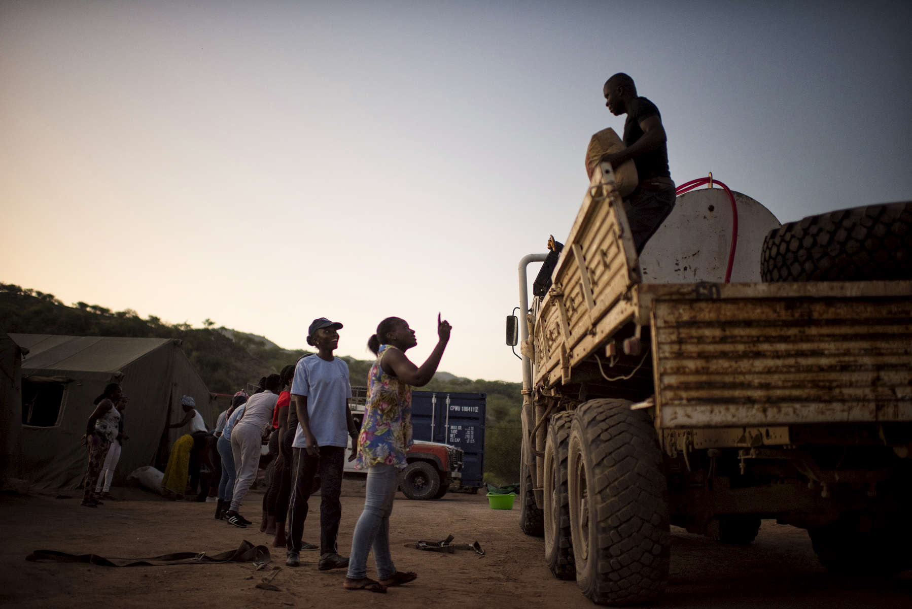 May 2, 2018: KANENGUERERE, ANGOLA - HALO deminer Esperança Ngando takes charge of unloading the truck on their first night back in Kanenguerere demining camp. 