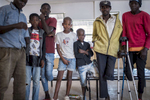 May 10, 2018: HUAMBO, ANGOLA - A group of boys who were seriously wounded while playing with a mortar round in December 2016 sit with older men, who are also mine accident victims at the rehabilitation center of a hospital in Huambo. Twelve year-old Antonio (patterned shirt), fourteen year-old Jeremy (red shirt), ten year-old Mario (white shirt) and eight year-old Manuel (black jacket) survived the accident, while their friend Frederico, ten, was killed. While there is an enormous need for prosthetic limbs in Angola, a country with an enormous number of mines laid during the civil war, they are unable to afford to import the materials necessary to make them. 